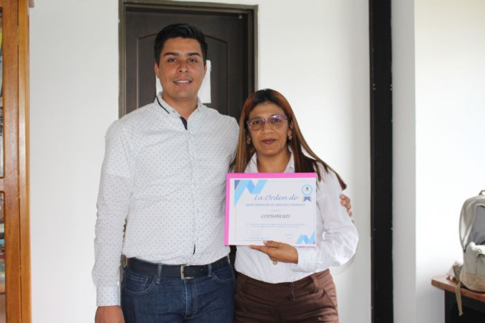 Viviana Macias Garcia, directora de la agencia San Luis recibe el reconocimiento a nombre de Coosanluis